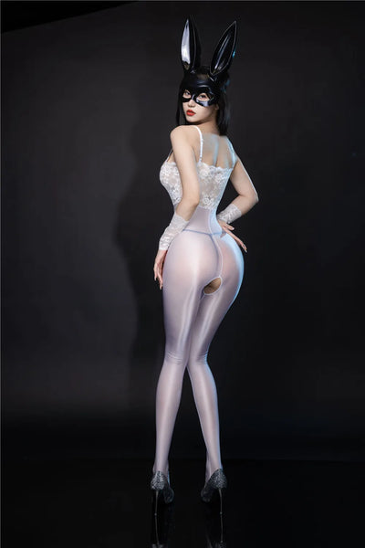 A woman posing in a white crotchless bodystocking featuring adjustable shoulder straps, a square neckline, white floral lace bodice, and glossy, close-footed leggings.