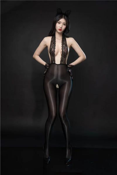 A woman posing in a black bodystocking featuring a black floral lace halter front panel, with an attached glossy sheer pantyhose with an open crotch.