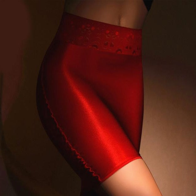 Red sheer mini skirt featuring a lace waistband and sensual shiny nylon. 
