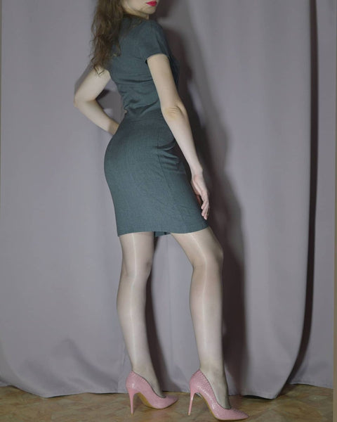 Lady wearing a dress paired with gray glossy pantyhose with high heels.