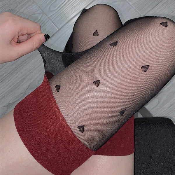 Close up  view of lady wearing black sheer thigh high stockings with red solid thigh band with black mini heartprints.