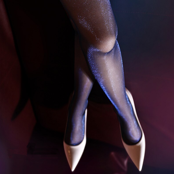 close up view of lady legs wearing sparkling blue pantyhose with white color shiny high heels