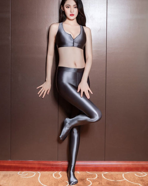 front view of lady wearing grey color top & legging set featuring a top with thick spaghetti straps, and front zipper closure, and pair with a matching over the toe legging with elastic waistband. 