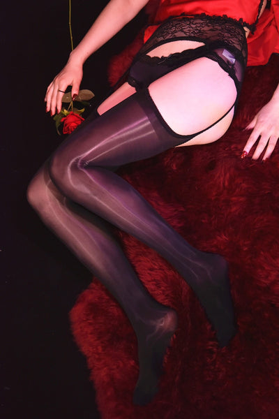 Front view of lady wearing black 8 denier shiny thigh-high stockings come with an attached lace garter belt.