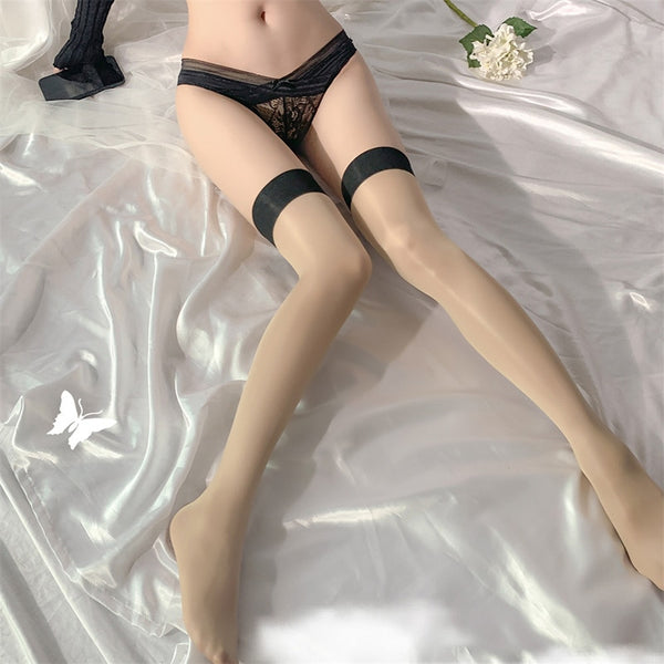 Front view of lady wearing a beige shiny sheer thigh-high stockings, featuring a black color wide band, showing off her feet.